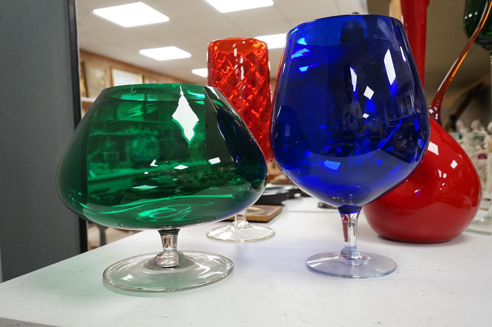 Five pieces of mid-century coloured glassware, to include a jug and an oversized brandy balloon, largest 48cm high